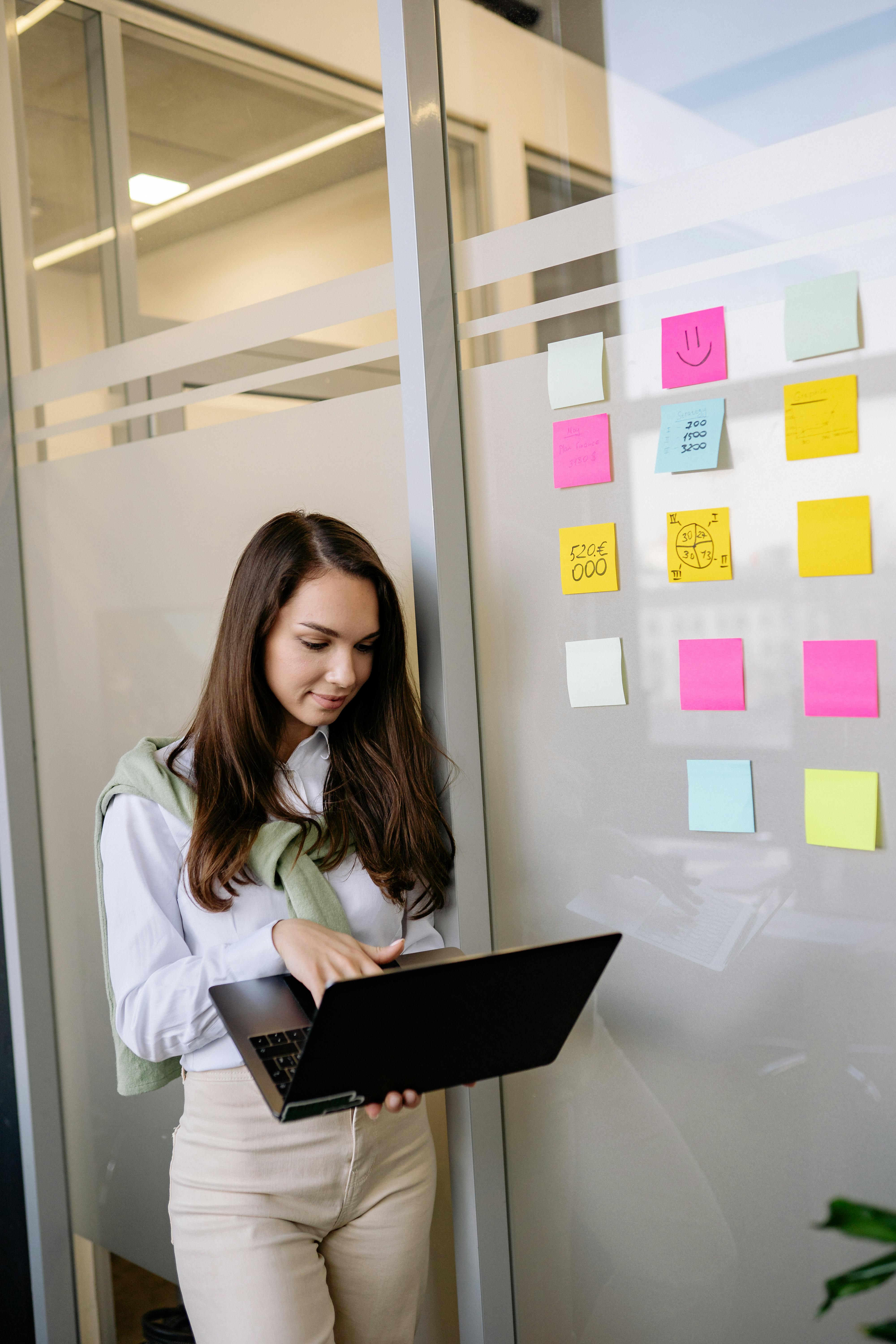Small business owner planning work on a laptop beside sticky notes